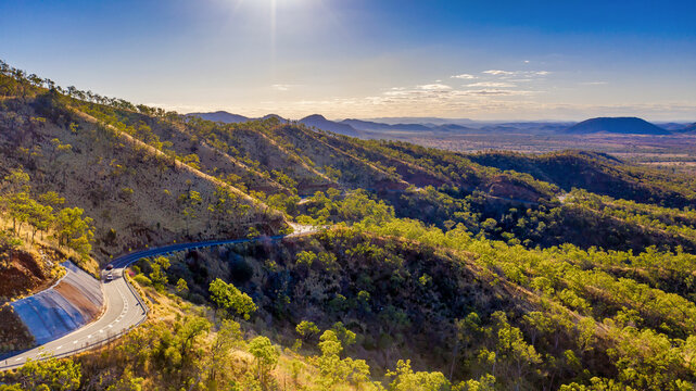 Horizontal photo of winding road in Mount Morgan with a steep road side with wild flowers and plants