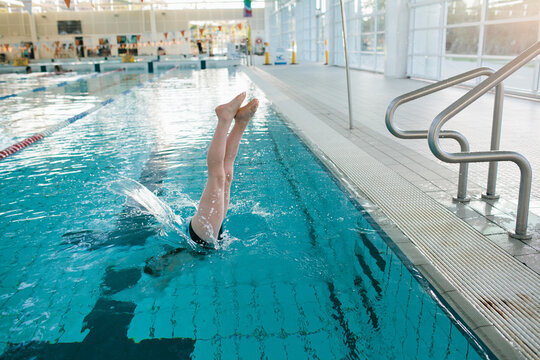 Girl jumping into a public pool