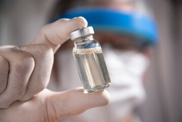 scientist holding ampoule filled clear liquid