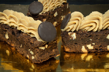 Chocolate brownies with nuts in a golden background.