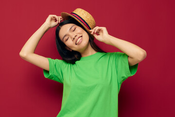Naklejka premium woman with Asian appearance gestures with his hands with a hat in a green t-shirt Lifestyle unaltered