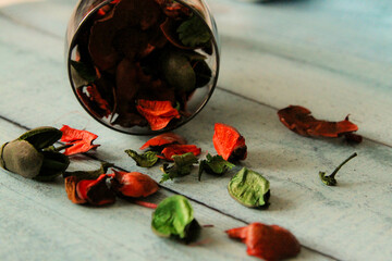 Dried flowers are scattered on the wooden floor.