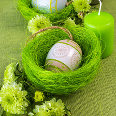 Set table with Easter decoration - eggs in nests and flowers.