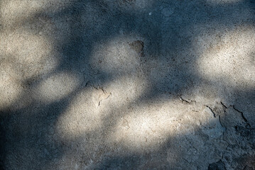 A texture of mottled light on gray cement crossed with cracks, offering a rugged, rough and grungy texture.