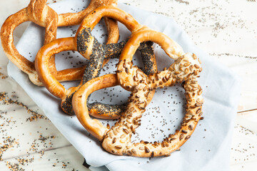 Fresh prepared homemade soft pretzels. Different types of baked bagels with seeds on a black background.