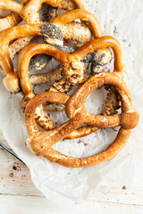 Fresh prepared homemade soft pretzels. Different types of baked bagels with seeds on a black background.