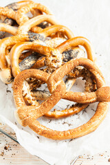 Fresh prepared homemade soft pretzels. Different types of baked bagels with seeds on a black background.