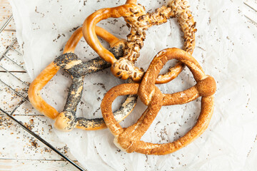 Fresh prepared homemade soft pretzels. Different types of baked bagels with seeds on a black background.