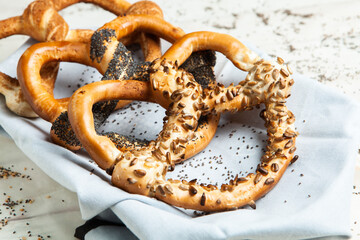 Fresh prepared homemade soft pretzels. Different types of baked bagels with seeds on a black background.