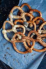Fresh prepared homemade soft pretzels. Different types of baked bagels with seeds on a black background.
