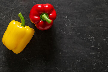 Sweet peppers red and yellow whole top view dark background, with space to copy text.