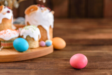 Festive cakes with white glaze, nuts and raisins with Easter eggs on the festive table