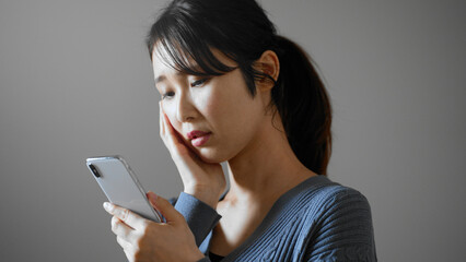 携帯電話を操作する若い女性