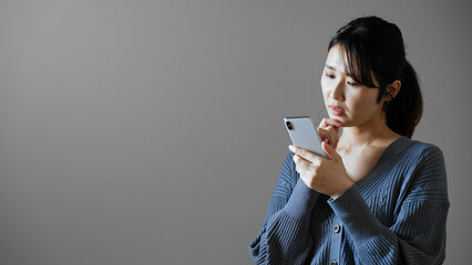 携帯電話を操作する若い女性