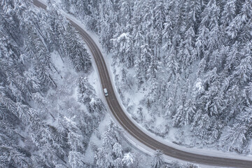 Snowy Winding Curving Mountain Road with Moving Car During Snowfall