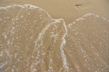 Sea surf, waves rolls on a sandy beach