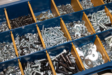 Many bolts in a plastic container closeup