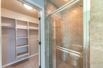 Walk-in closet with shelving units near the shower stall