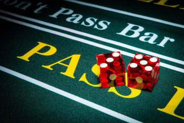 Professional casino-style dice sit on the pass section of a craps table.