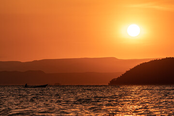 Fototapeta premium Beautiful orange sunrise over Lake Baringo with fisherman, Kenya 