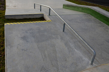 Skateboard park with concrete cement surface with concrete skateboard obstacles is designed for...