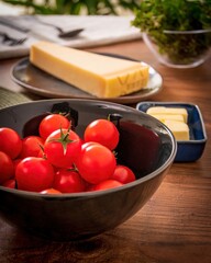 Cherry tomatoes in black cup with parmesan cheese and butter