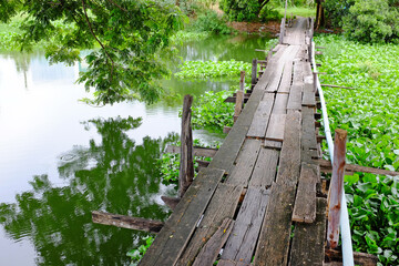 Old wood bridge crossing the nature canal in Thailand.