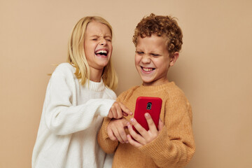 Little boy and girl with a red phone together technologies isolated background