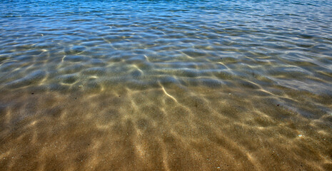 Sea abstract or rippled water texture background. Calm water surface texture with splashes and waves. Abstract nature background. Surface of blue ocean water.