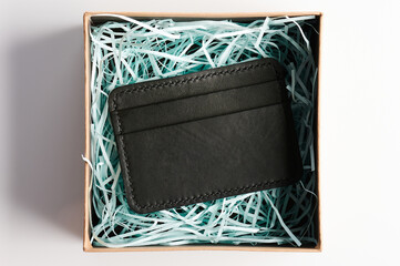 Black leather purse in open paper box