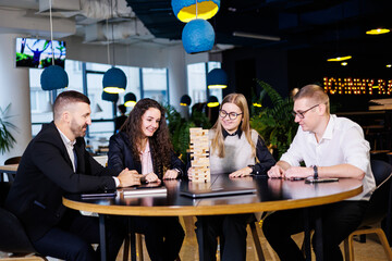 Businessmen play jenga. Business holiday concept. Young people play board games in the office