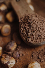 nuts and cacao powder on wooden background
