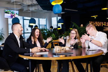 Businessmen are playing Jenga games. They sit in the office and play games. Concept photo for design and work.