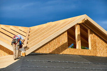 A worker building a passivhaus house with wood