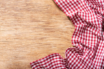 Fototapeta na wymiar red checkered tablecloth on wooden background