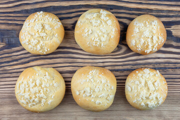 Buns fresh, round, sprinkled, baked, on a wooden table.