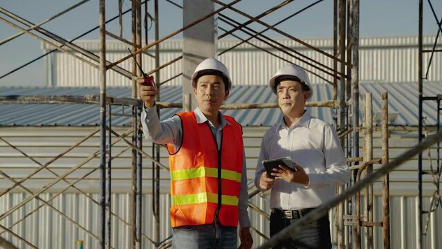 On outdoor construction sites, Asian engineers and architects Consulting and planning the construction of the building to be completed according to the form and schedule.
