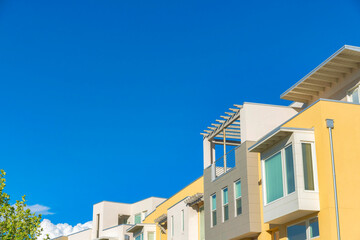 Row of apartment buildings with rooftops and pergola at Daybreak in South Jordan, Utah