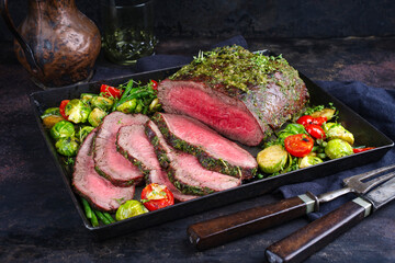 Traditional Commonwealth Sunday roast with sliced cold cuts roast beef with Brussel sprouts,...