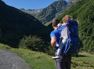 Fototapeta na wymiar father with baby carrier backpack hiking in the mountains. father and daughter , family adventure, outdoor vacation, healthy life.