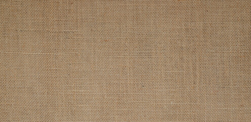 Fototapeta na wymiar Hessian sackcloth burlap woven texture background / cotton woven fabric background with flecks of varying colors of beige and brown. with copy space. office desk concept.High Resolution horizontal . 