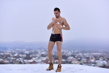 Naked man hardening in cold snow. Winter fun, tempering procedures. Guy snow showers for the...