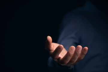 Obraz premium Businessman with empty hand on dark background