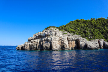 Fototapeta na wymiar Ionian Sea, Rock and Blue Sky during Sunny Day in Paxos Island. Summer Scenery of Greek Landscape.