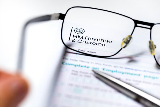 UK Tax Papers and Forms from HM Revenue Customs under a glass