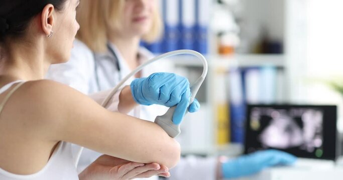 Doctor making ultrasound of elbow joint to woman patient in clinic 4k movie