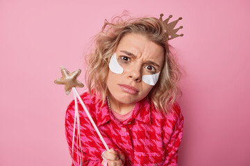 Displeased young woman has upset expression looks attentively at camera feels discontent after...