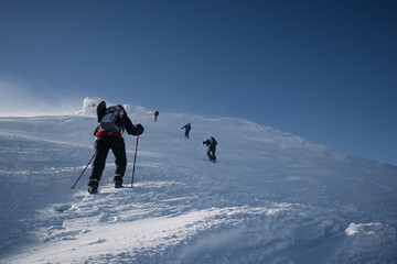 people climbers climb a steep snowy slope