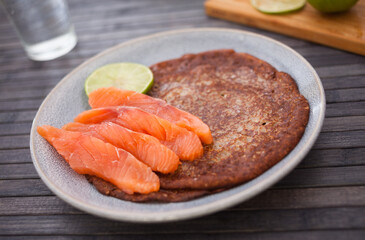 salted salmon fillet with buckwheat pancakes and lime