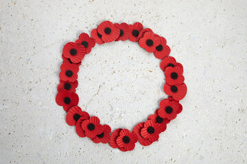 Anzac day. Australian and New Zealand national public holiday or Remembrance day. Red poppies wreath on biege stone background